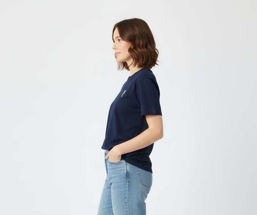 Side view of woman wearing navy blue women’s t-shirt with short sleeves, casual fit on plain background
