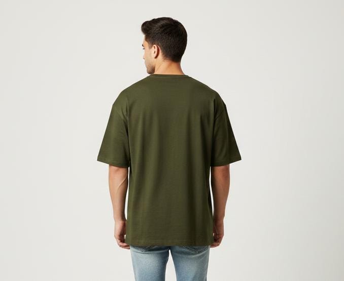 Back view of man wearing olive green oversized men’s t-shirt, plain design, short sleeves, casual fit on light background
