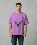 Man wearing purple oversized men’s t-shirt with front graphic print and chest logo, casual fit on plain background
